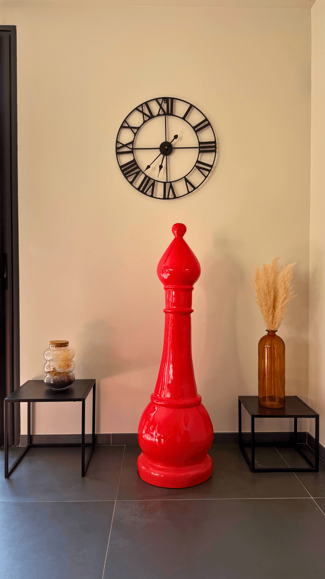 Statue d’échecs géante GRANDIOSE en résine rouge représentant un fou, placée en intérieur moderne avec déco minimaliste. Idéale pour sublimer salons ou halls.