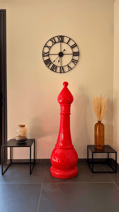 Statue d’échecs géante GRANDIOSE en résine rouge représentant un fou, placée en intérieur moderne avec déco minimaliste. Idéale pour sublimer salons ou halls.