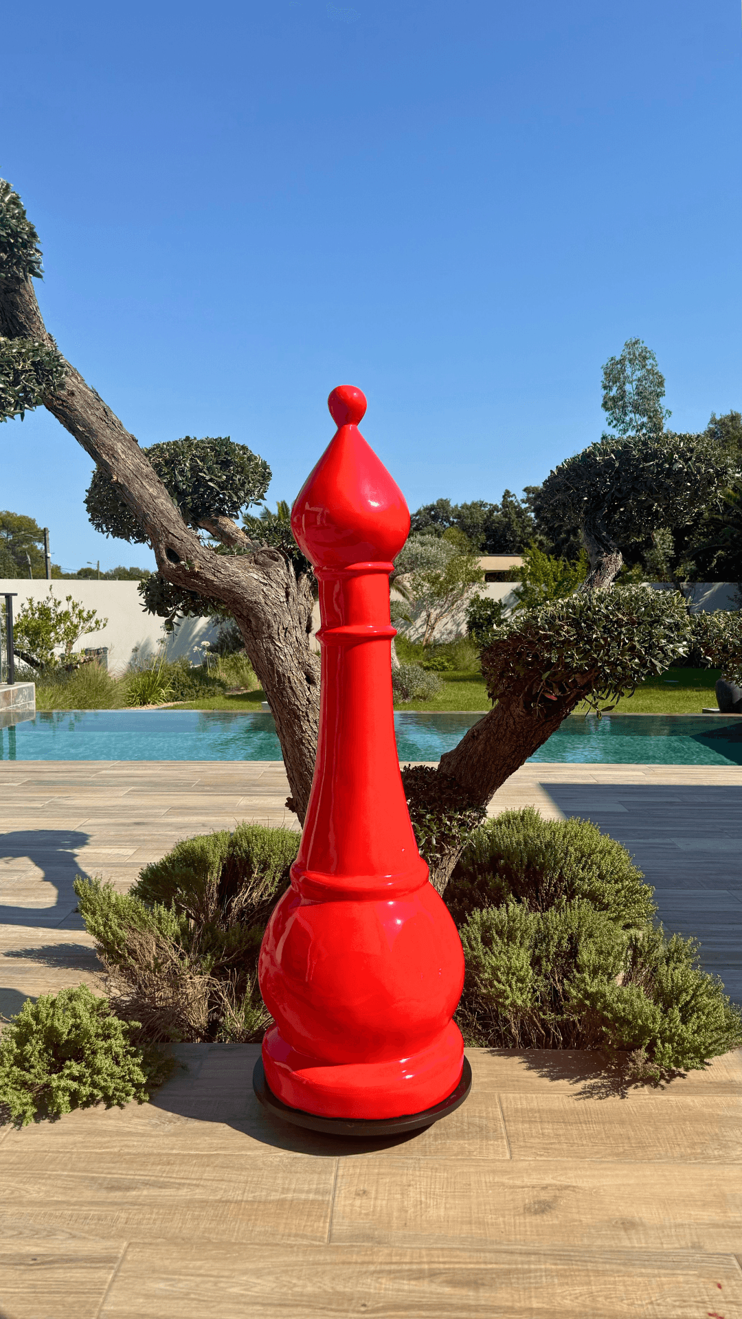 Statue d’échecs géante GRANDIOSE en résine rouge représentant un fou, design contemporain pour décoration extérieure de jardin ou terrasse.